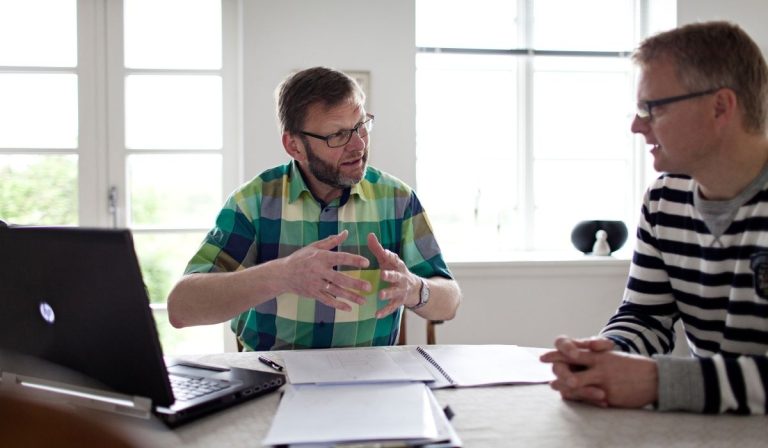 Forsikringsmægler snakker med landmand